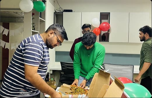 Team members celebrating with cake